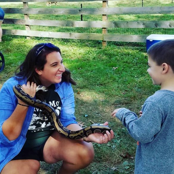 Erynn DeGennaro shows a ball python to a child attending a Delaware Nature Society program.