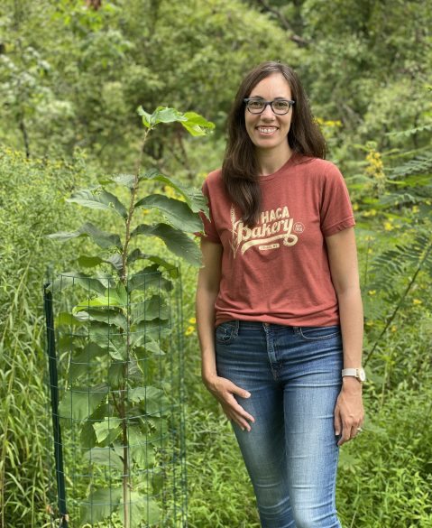 Kate McDonald beside one of the pawpaws she bought from the Native Plant Sale