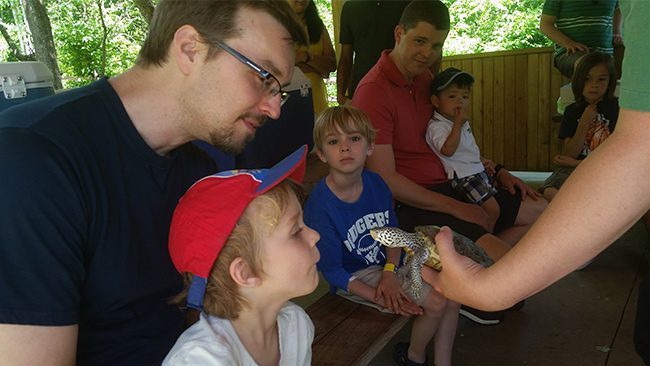 Birthday party family looking at turtle